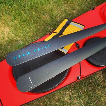 Gram Kajak paddle displayed on the back deck of a sea kayak