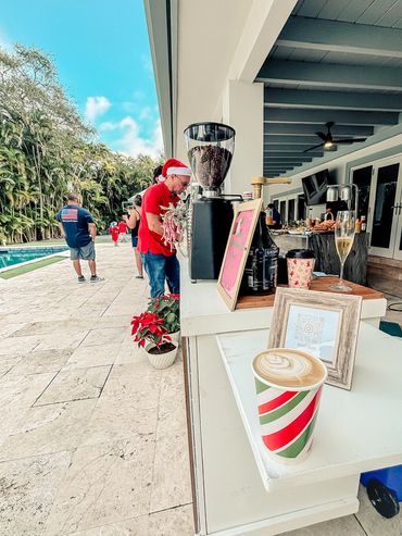 Outdoor coffee stand with holiday decorations and people in festive attire.