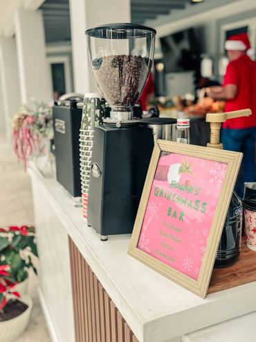 Coffee beans and a sign for Grinchmass Bar on a festive counter.