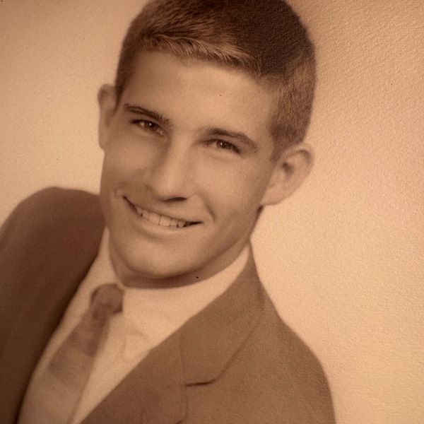 Young man in suit smiling for portrait.
