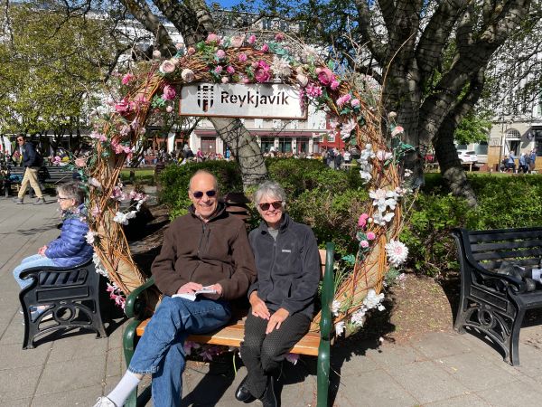 Couple sitting on a flower-framed bench in Reykjavik.