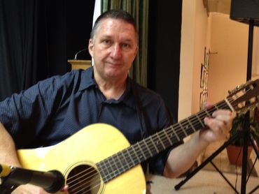 Professional guitarist performing live with vocal microphone