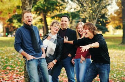 A family playing and laughing in a park.