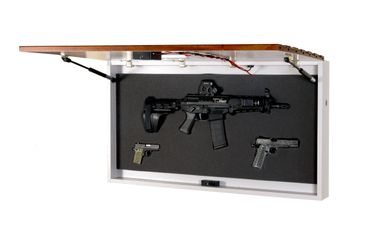 TacticalTrap wall decor hanging on a white wall, open with a riffle and 2 pistols mounted within it.