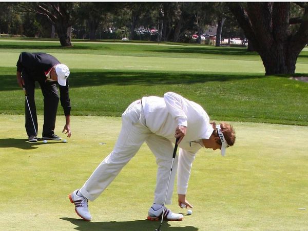 Person bending on green.