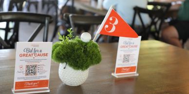 Table display for a charity bid with a number 3 flag.