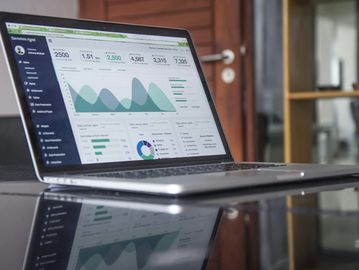 Laptop displaying detailed analytics dashboard with graphs and charts.