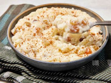 Creamy rice pudding with raisins and cinnamon in a bowl.