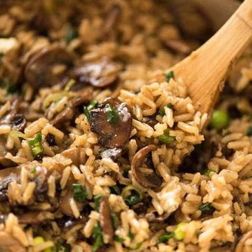 A close-up of mushroom fried rice with herbs and spices.