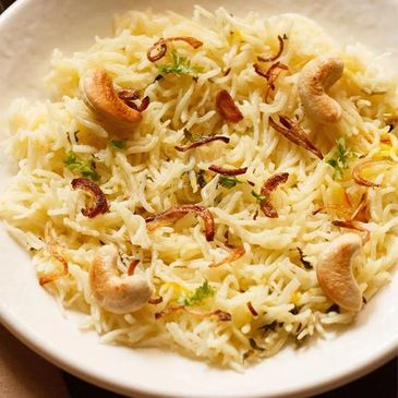 A plate of fragrant biryani rice garnished with fried onions and cashew nuts.