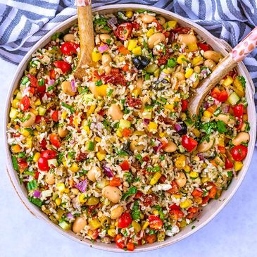 Colorful rice and bean salad with fresh vegetables in a bowl.