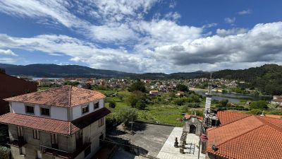 Scenic view of a town with tiled roofs and a river under a blue sky.