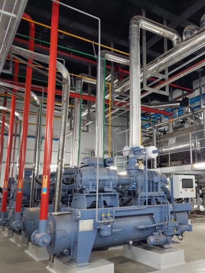 Industrial machinery with red pipes in a factory setting.
