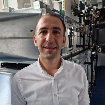 Man smiling in industrial setting.