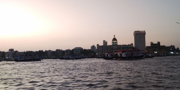 City skyline at sunset with water in the foreground.