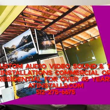 Interior with dual TVs mounted from ceiling, showing scenic images, and commercial installation services advertised.