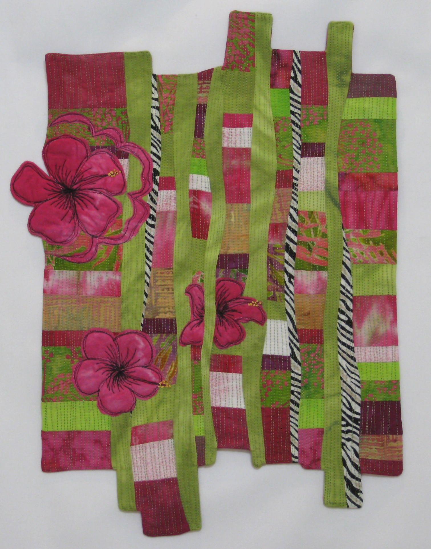 Colorful patchwork quilt with pink flowers and green stripes.