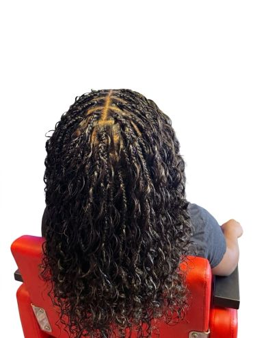 Back view of braided and curly hairstyle.
