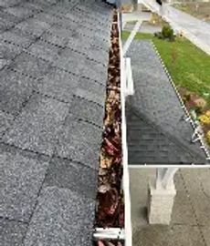 A clogged gutter filled with leaves and debris on a house roof.