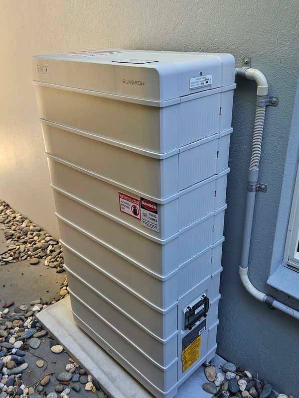 White Sungrow energy storage unit installed outdoors against a wall.