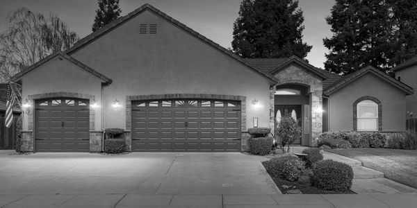 A modern suburban house with a triple garage and well-maintained landscaping.