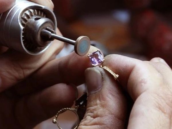 Jeweler polishing a gemstone ring.