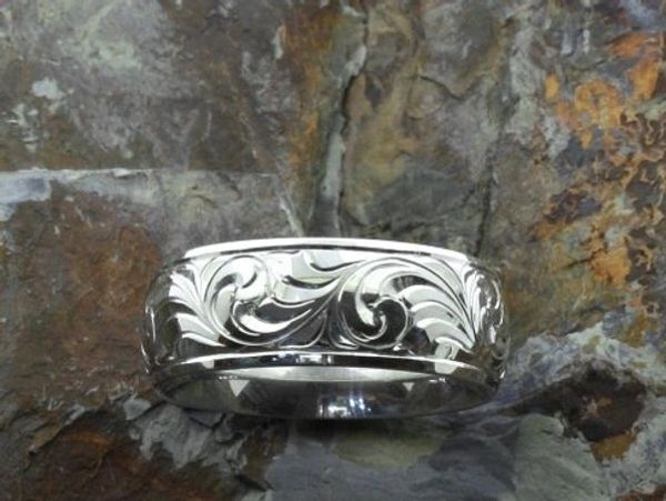 Engraved silver ring on rock.