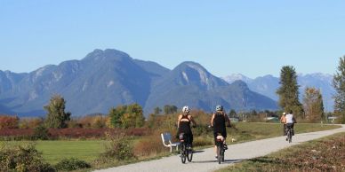 People biking on a trail with mountains in the background, bike tours