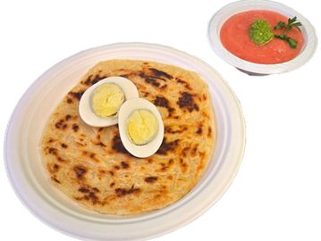 Crispy layered malawach with boiled eggs and tomato dip authentic Israeli flavor made fresh daily.