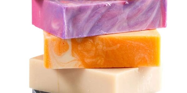 Three colorful handmade soap bars stacked on each other.