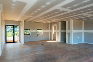 Unfinished room with drywall and wooden flooring.
