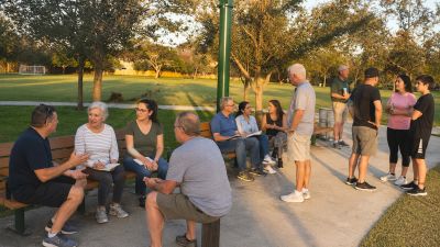 Residents gather at a HAMMOCKS park pavilion discussing neighborhood issues with neighbors together.