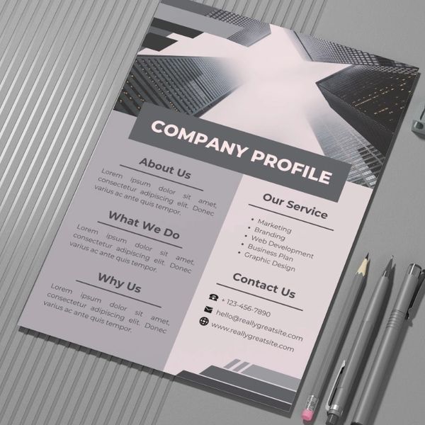 A printed company profile document displayed alongside pencils and office materials.