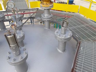 Industrial equipment with pressure gauge and safety valves on a metal platform.