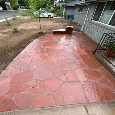 Newly installed red flagstone patio with a fresh, wet finish.