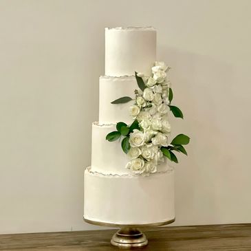 A 4 tier wedding cake decorated with roses