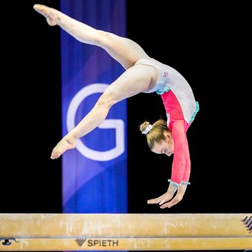 Elite gymnast Olivia Ahern flipping on beam at International Gymnix competition in Montréal, Canada