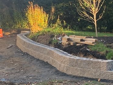 Custom designed retaining wall built to curve around natural landscape.