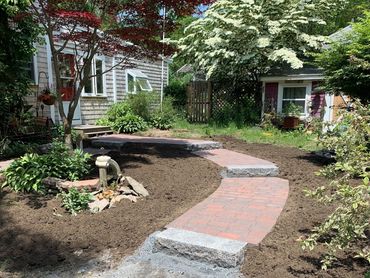 Granite steps leading to a brick paver pathway to entrance of home.