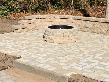 Patio featuring a mix of natural stone and retaining wall. Custom firepit with metal insert.