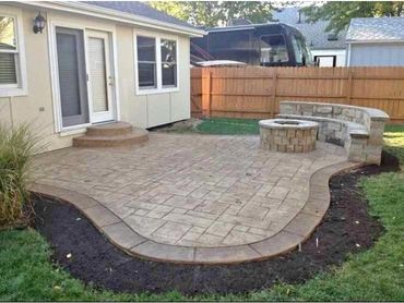 Cozy backyard patio with pavers and lush green landscaping.