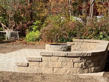 Beautiful stone wall with custom patio and custom firepit.