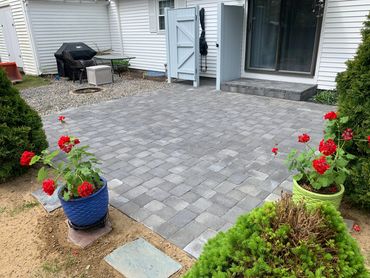 Custom-designed paver patio with colorful flower beds and garden.