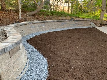 Custom designed retaining wall built to curve around natural landscape.