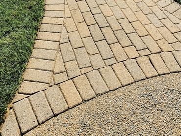 Rustic and precise stonework for paver brick pathway.