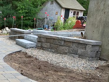 Custom retaining wall built for granite steps leading to a custom brick pathway and outdoor garden.