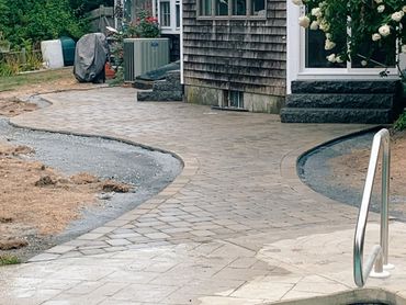 Granite steps down to a custom patio and pathway combo which connects to the pool area.