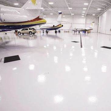 Aircraft hanger floors with temperature and impact resistance, engineered resin flooring