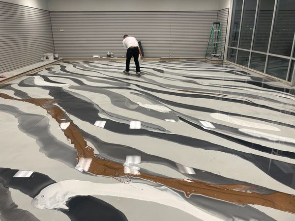 Showing the class how to lay down a metallic epoxy design for this showroom space in McKinney Texas