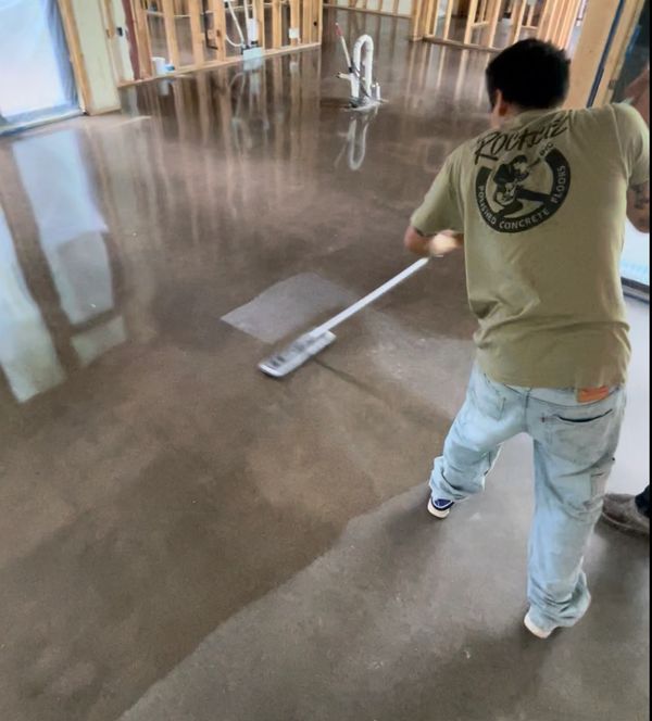 Damian applying sealer on polished concrete floors during residential construction